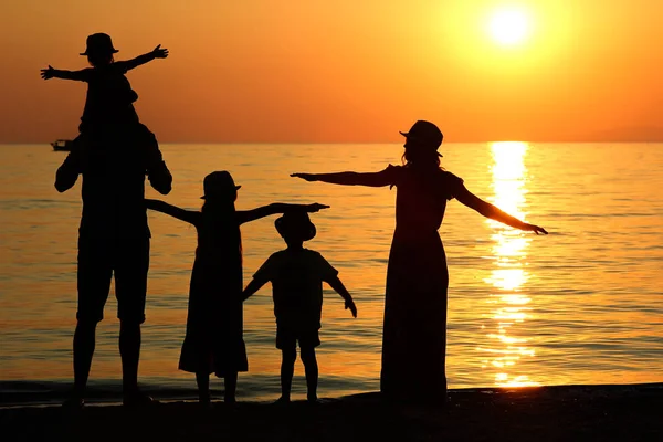 Silueta familiar al atardecer junto al mar ... — Foto de Stock