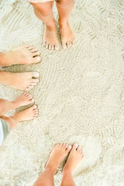 Deniz kenarındaki kumların üzerinde güzel bacaklar