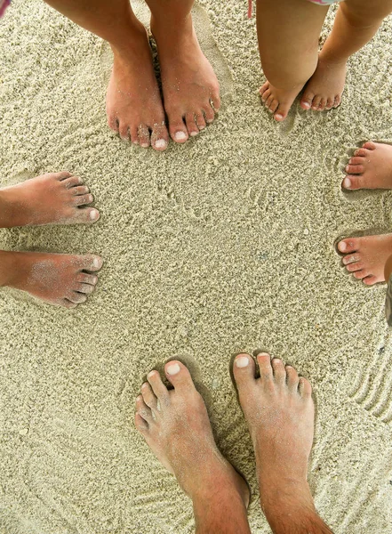 Familie voeten op het zand op het strand — Stockfoto