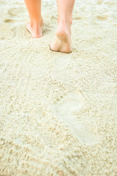 Hermosas piernas en la arena junto al mar — Foto de Stock