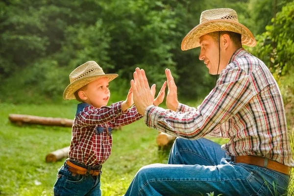 Šťastné dítě s kovbojem rodiče v přírodě v terénu — Stock fotografie