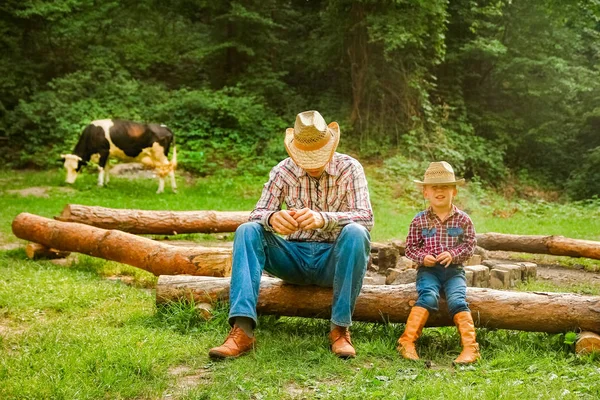 Gelukkig kind met cowboy ouder in de natuur in het veld — Stockfoto