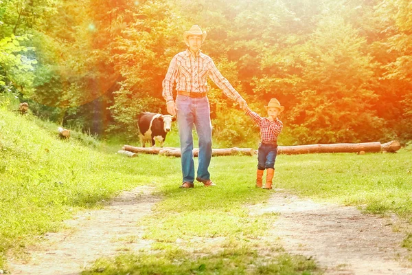 Bambino felice con genitore cowboy in natura nel campo — Foto Stock