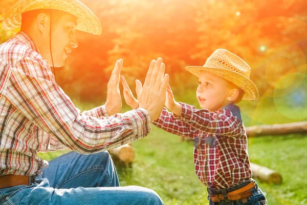 Šťastné dítě s kovbojem rodiče v přírodě v terénu — Stock fotografie