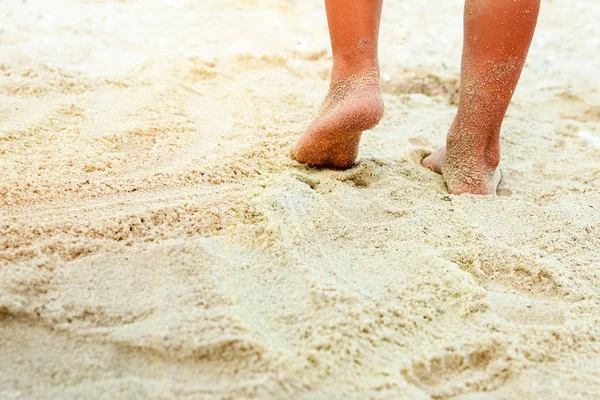 Schöne Beine auf dem Sand am Meer — Stockfoto