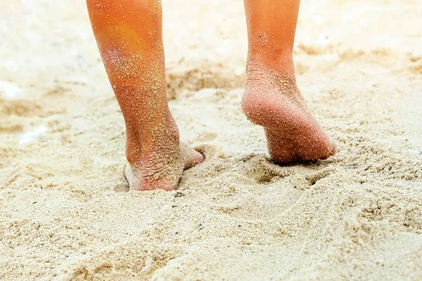 Hermosas piernas en la arena junto al mar — Foto de Stock