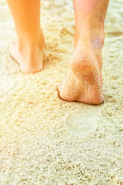 Mooie benen op het zand aan zee — Stockfoto