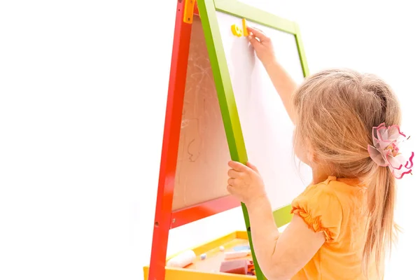 Happy baby girl beautiful painting on the easel on a white backg — Stock Photo, Image