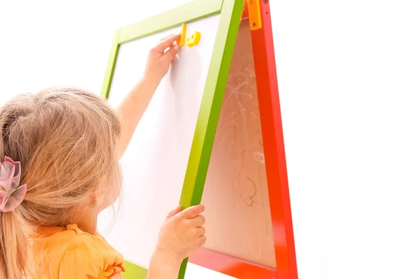 Happy baby girl beautiful painting on the easel on a white backg — Stock Photo, Image