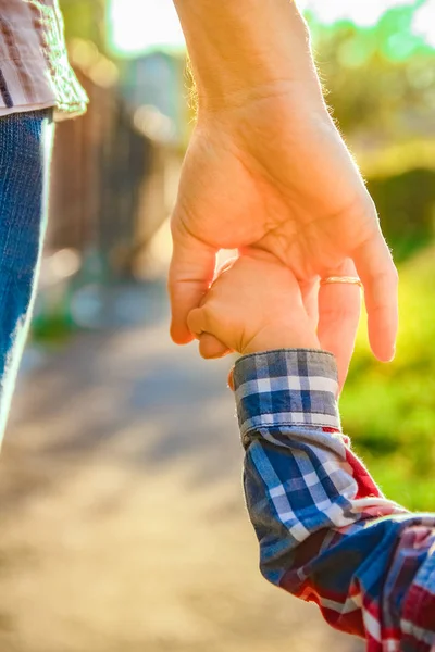 El padre sosteniendo la mano del niño con un fondo feliz —  Fotos de Stock