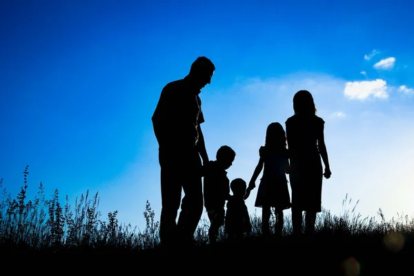 Felice famiglia all'aperto nella silhouette del parco — Foto Stock
