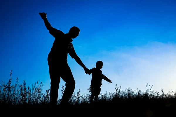 Genitore felice con bambino nel parco all'aperto silhouette — Foto Stock