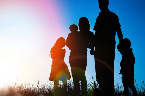 Gelukkige familie buitenshuis in het Park silhouet — Stockfoto