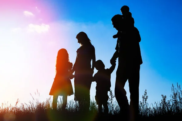 Felice famiglia all'aperto nella silhouette del parco — Foto Stock