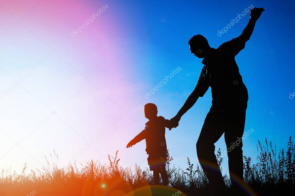 happy parent with child in the park outdoors silhouette