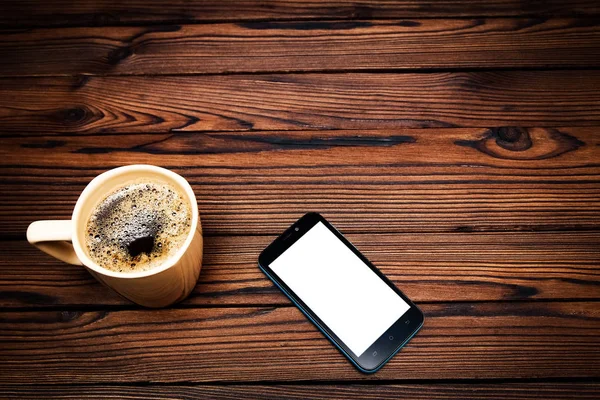 Lekkere koffie met telefoon op achtergrond — Stockfoto