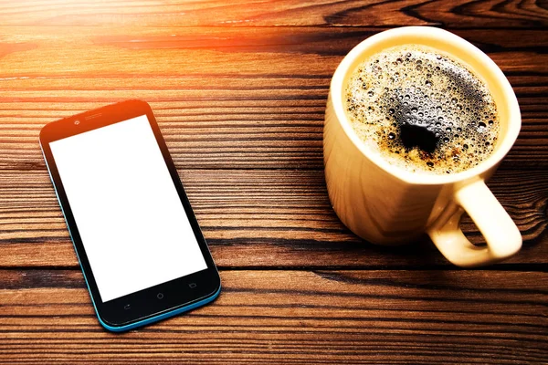 Lekkere koffie met telefoon op achtergrond — Stockfoto