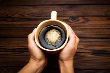 kahve ahşap arka plan üzerinde tutan eller