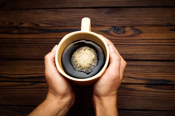 kahve ahşap arka plan üzerinde tutan eller