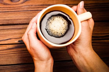 kahve ahşap arka plan üzerinde tutan eller