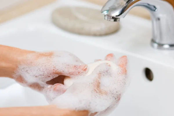 Hygienická koncepce. Mytí rukou mýdlem pod kohoutkem s w — Stock fotografie