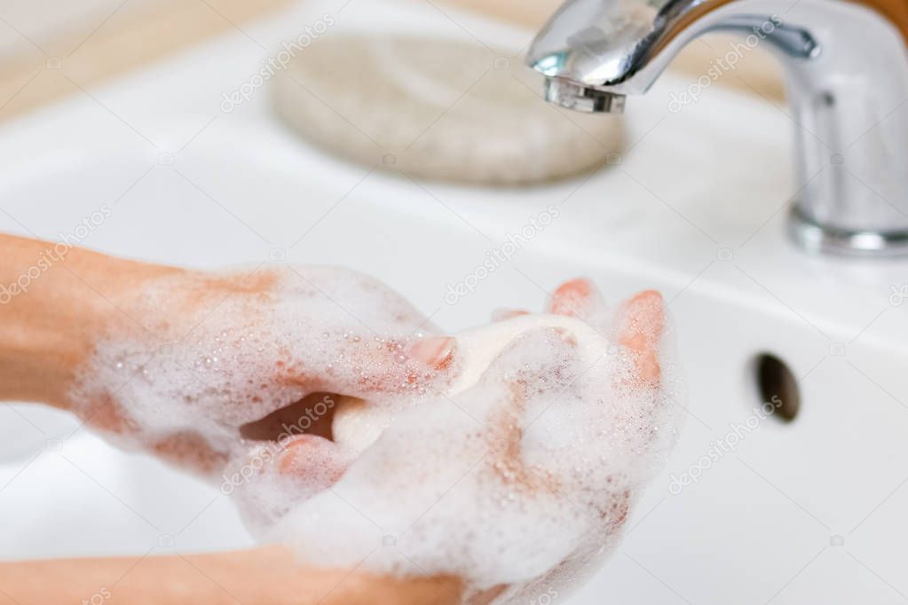 Hygiene concept. Washing hands with soap under the faucet with w