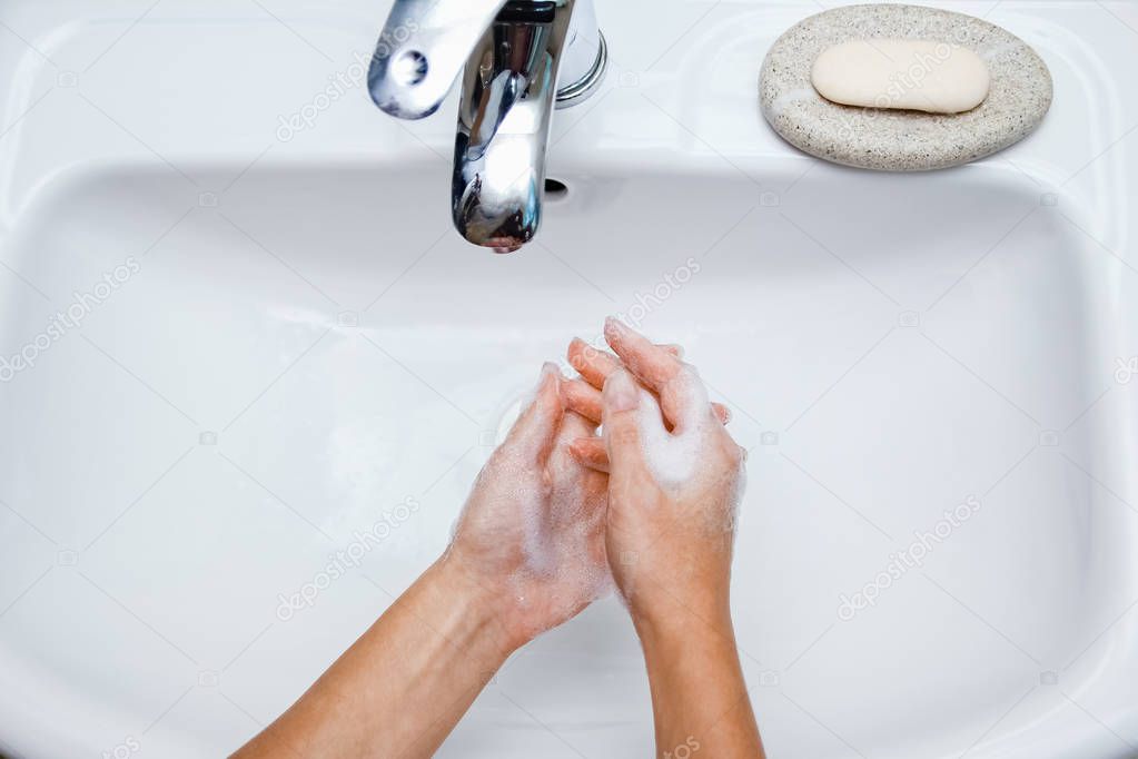 Hygiene concept. Washing hands with soap under the faucet with w