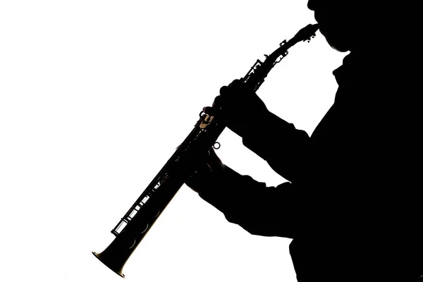 Saxafon auf weißem Hintergrund in den Händen einer Musiker-Silhouette — Stockfoto