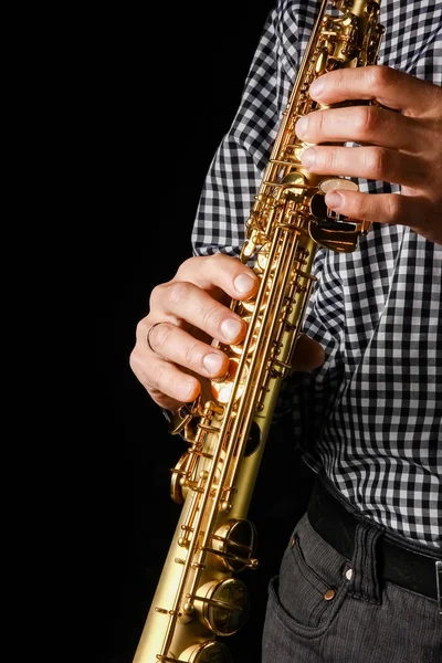 Soprano saxofone em mãos sobre um fundo preto — Fotografia de Stock
