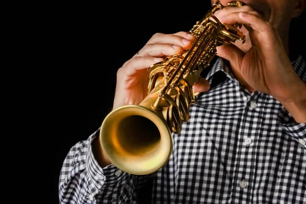 Saksofon sopranowy w dłoniach na czarnym tle — Zdjęcie stockowe
