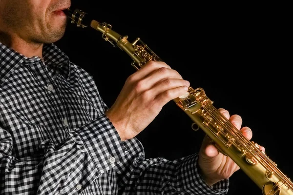 Soprano saxofone em mãos sobre um fundo preto — Fotografia de Stock