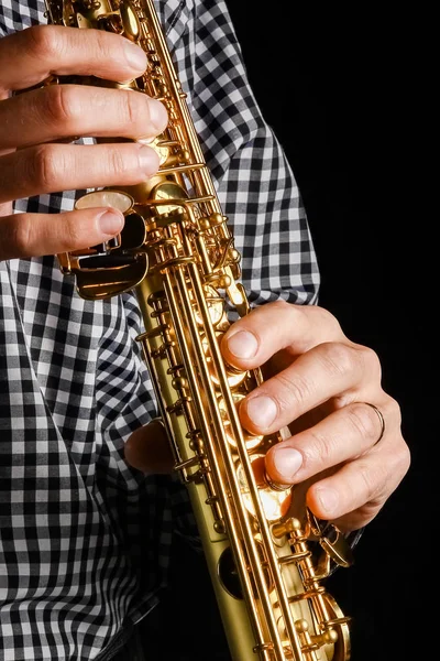 Soprano saxophone in hands on a black background — Stock Photo, Image