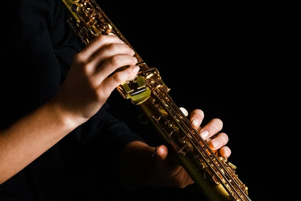 Soprano saxofone em mãos sobre um fundo preto — Fotografia de Stock