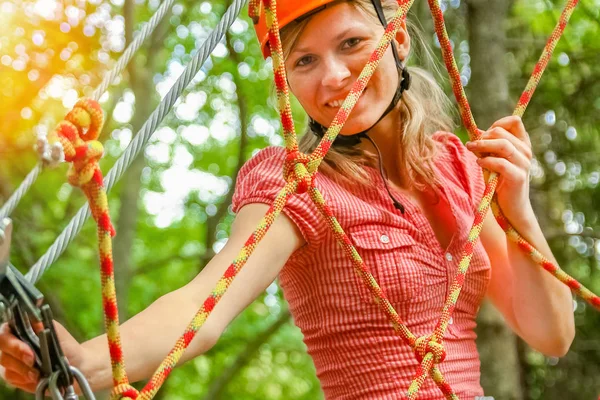 Красива дівчина в парку на мотузках досягає на відкритому повітрі — стокове фото