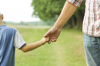 ebeveyn bir l çocuğun elini tutar