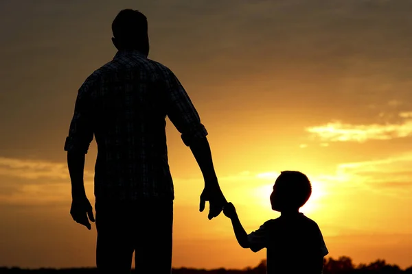 Silueta otce a syna při západu slunce — Stock fotografie
