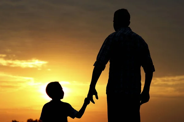 父亲和儿子在日落的剪影 — 图库照片