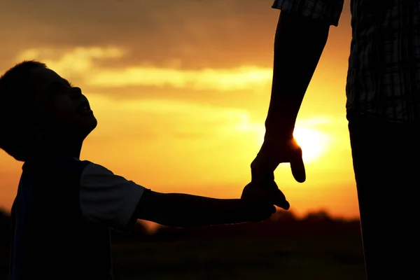 Silhouette förälder innehar hand av ett barn — Stockfoto