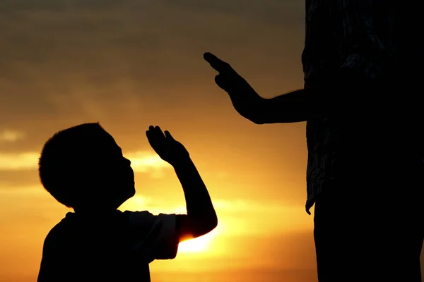 Rodič siluety drží ruku dítěte — Stock fotografie