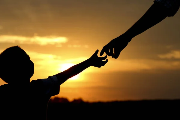 Silueta padre sostiene la mano de un niño — Foto de Stock