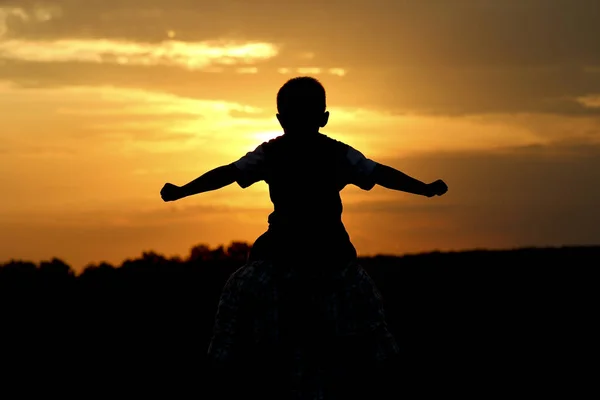 Silhouette de père et fils au coucher du soleil — Photo