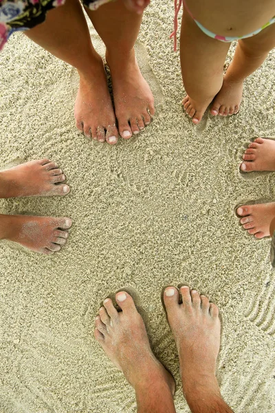 Familie voeten op het zand op het strand — Stockfoto