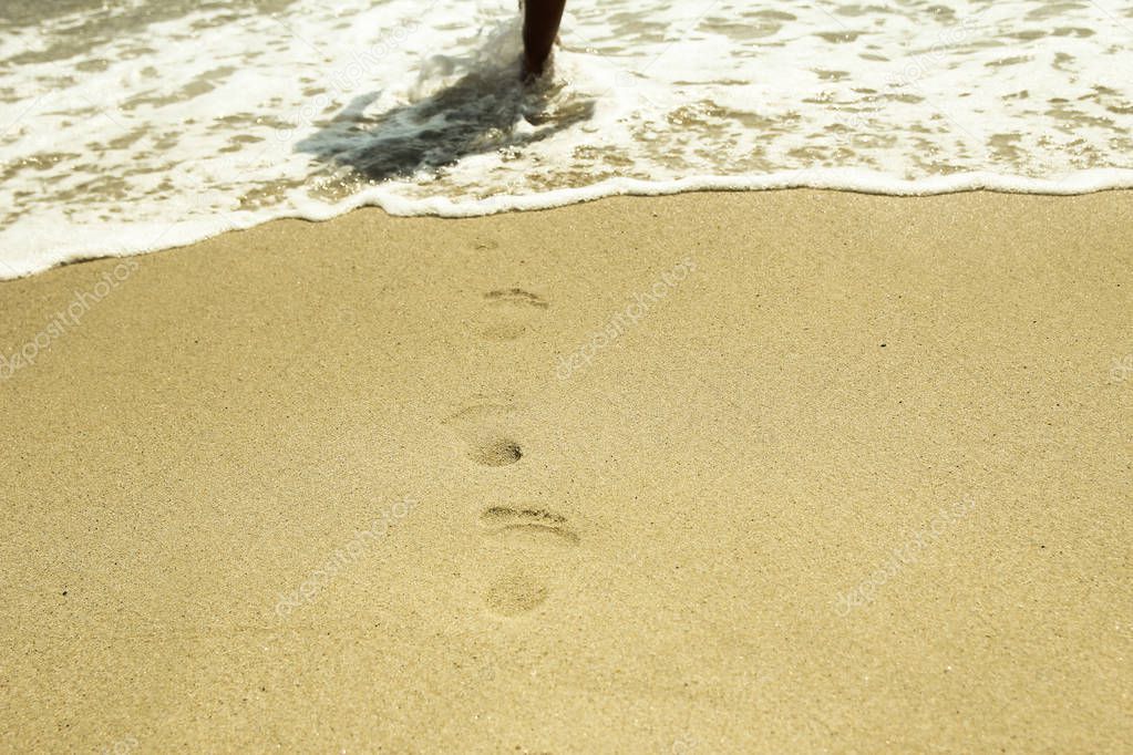 footprints in the sand on the beach