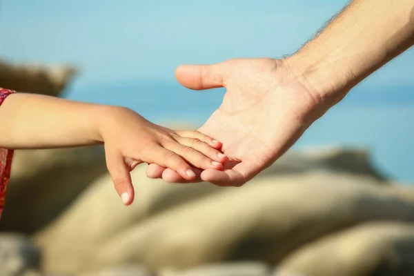 在海边的父母和孩子的美丽的手 — 图库照片
