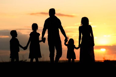 Denizde mutlu bir aile silueti. Doğada yansıması var.