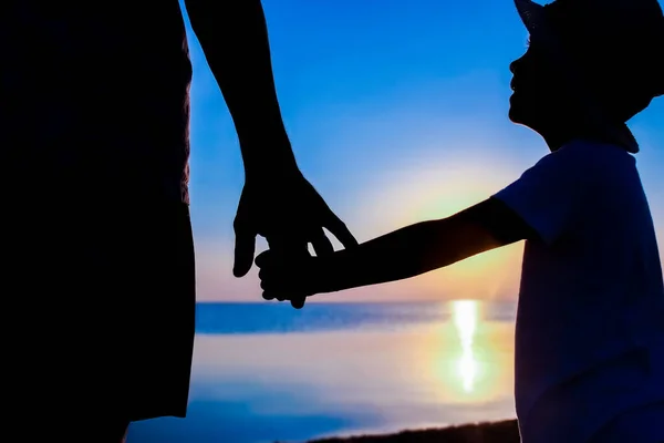 快乐的父亲和孩子们在海边手挽手 勾勒出大自然的轮廓 — 图库照片