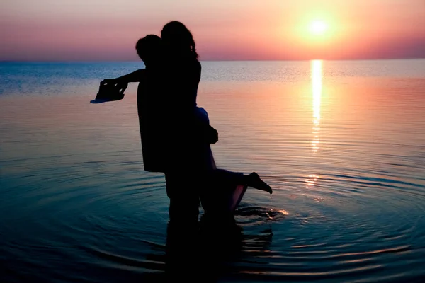 夕阳西下的大海中 一对快乐的情侣在大自然中旅行的轮廓上 — 图库照片