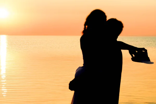 夕阳西下的大海中 一对快乐的情侣在大自然中旅行的轮廓上 — 图库照片