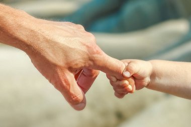 Deniz kenarındaki anne ve babanın güzel elleri.