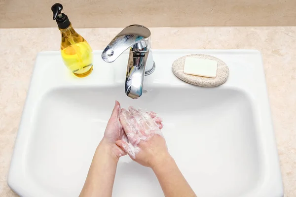 Hands with soap are washed under the tap with water. Clean from infection and dirt and virus. At home or in the hospital ablution office.